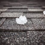 Large hailstones on a dark gray shingled roof
